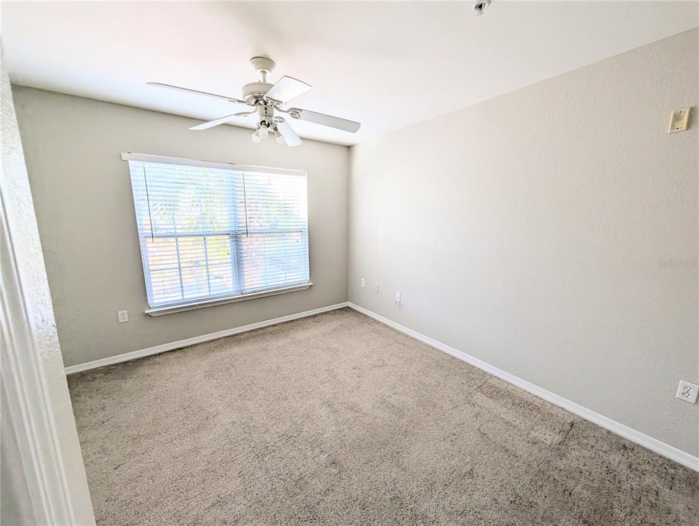 5531 Rosehill Road, Unit 203 Sarasota, FL 34233 - Photo 12 of 18 an empty room with windows and chandelier fan