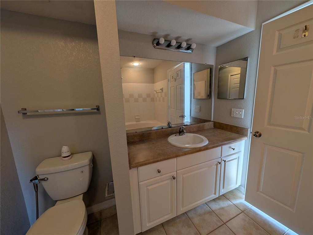 5531 Rosehill Road, Unit 203 Sarasota, FL 34233 - Photo 15 of 18 a bathroom with a granite countertop sink toilet and mirror