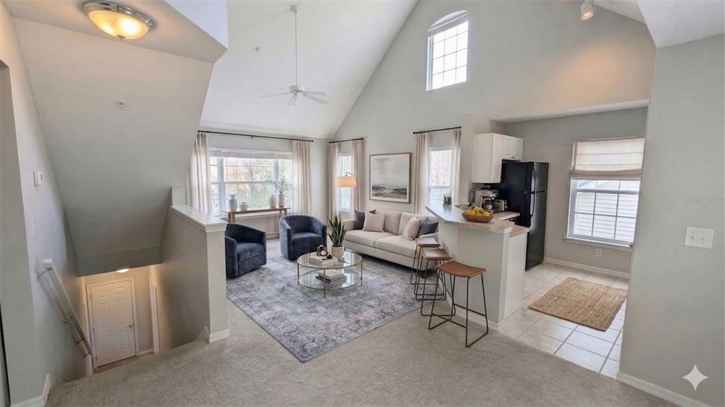 5531 Rosehill Road, Unit 203 Sarasota, FL 34233 - Photo 2 of 18 a living room with furniture a rug kitchen view and a large window
