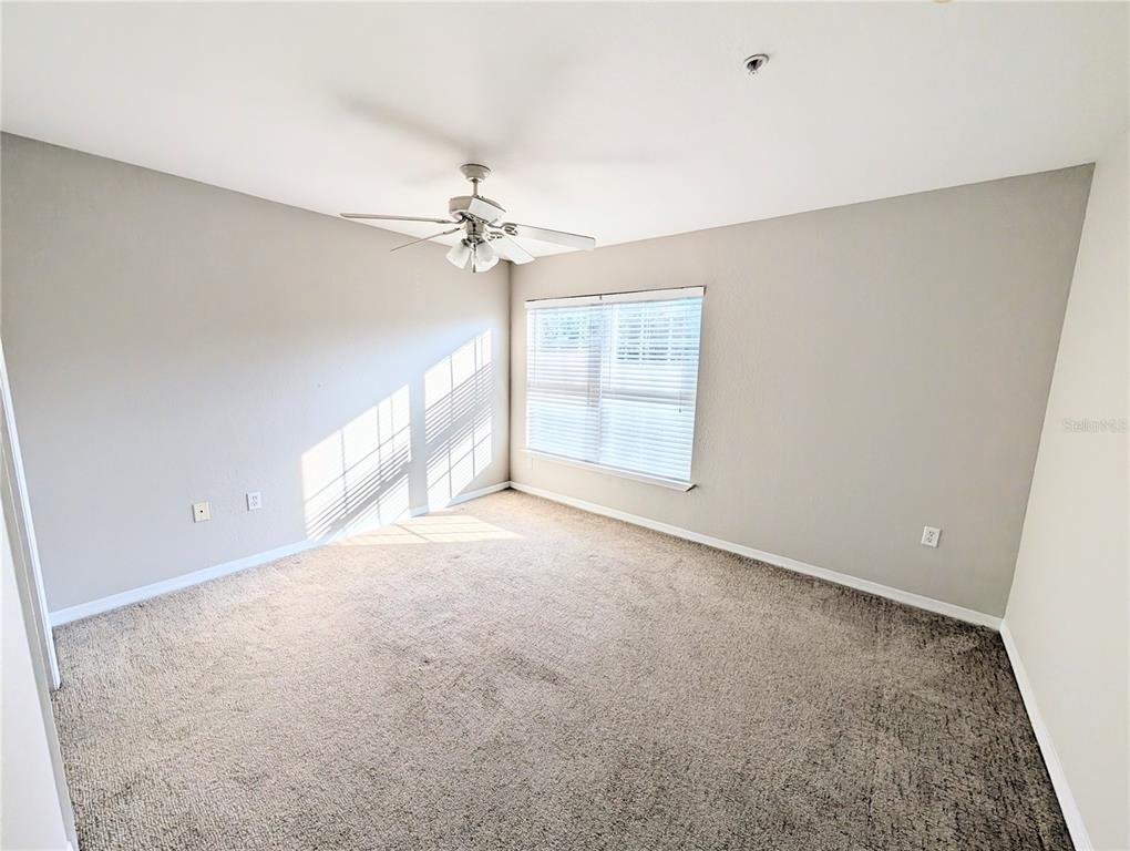 5531 Rosehill Road, Unit 203 Sarasota, FL 34233 - Photo 7 of 18 an empty room with windows and chandelier fan