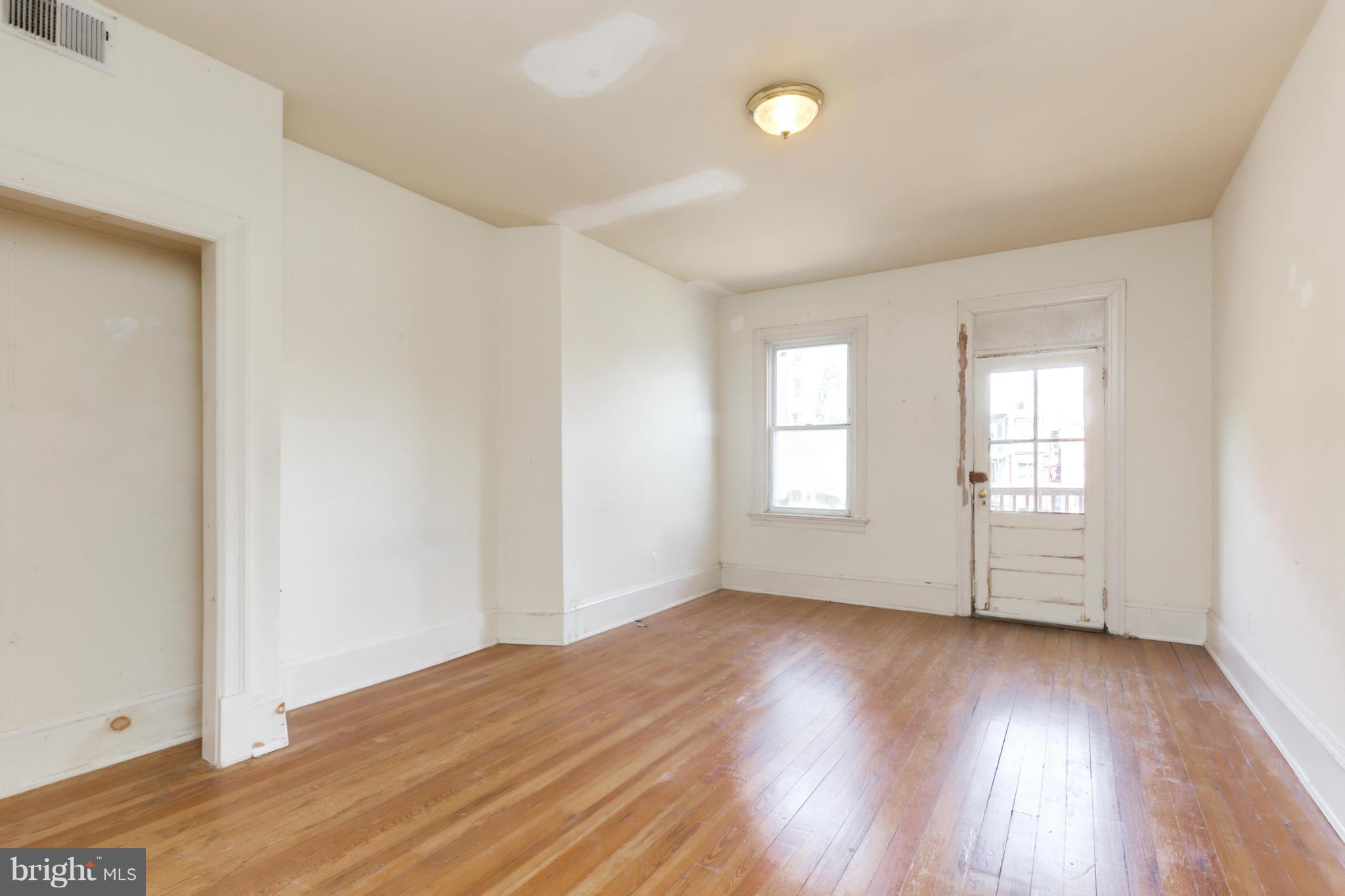 1823 Kalorama Road Northwest Washington, DC 20009 - Photo 12 of 20 an empty room with wooden floor and windows