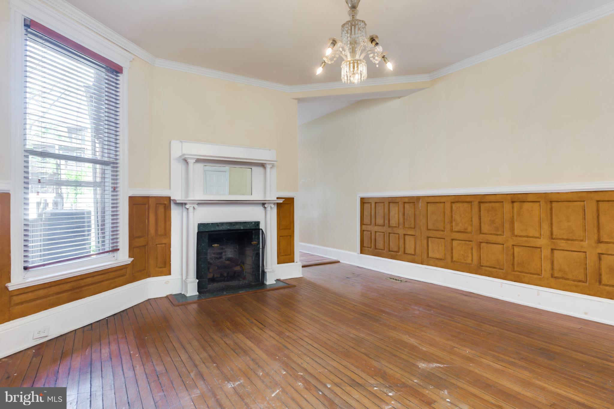 1823 Kalorama Road Northwest Washington, DC 20009 - Photo 5 of 20 a view of an empty room with wooden floor fireplace and a window