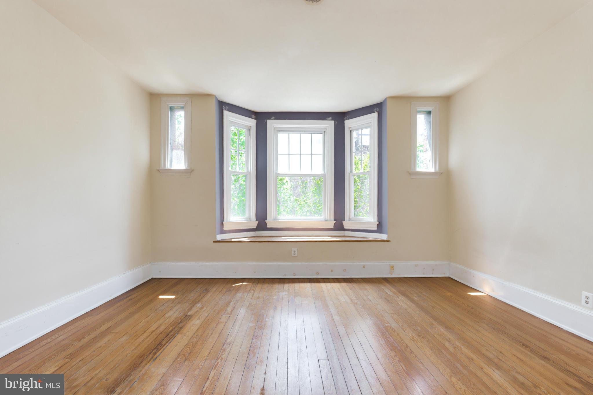 1823 Kalorama Road Northwest Washington, DC 20009 - Photo 7 of 20 an empty room with wooden floor and windows