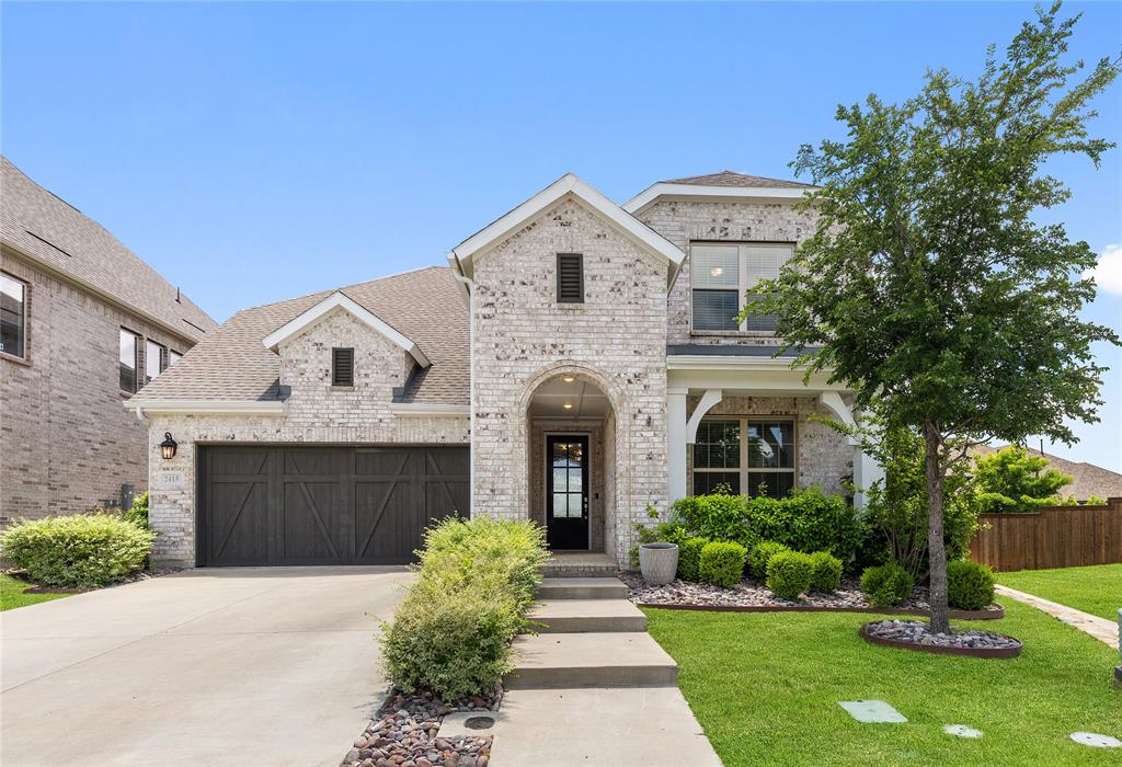 a front view of a house with a garden and plants