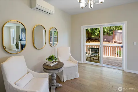 a view of a dining room with furniture a potted plant and wooden floor