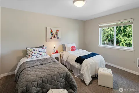 a bedroom with two beds and a large window