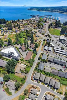 an aerial view of a city with lots of residential buildings and ocean view in back