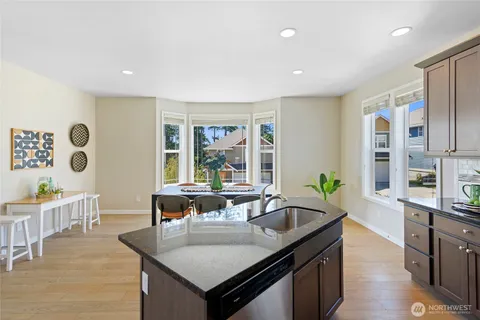 a kitchen with stainless steel appliances granite countertop a sink and a refrigerator