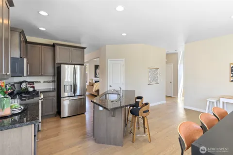 a kitchen with stainless steel appliances granite countertop a refrigerator and a stove top oven