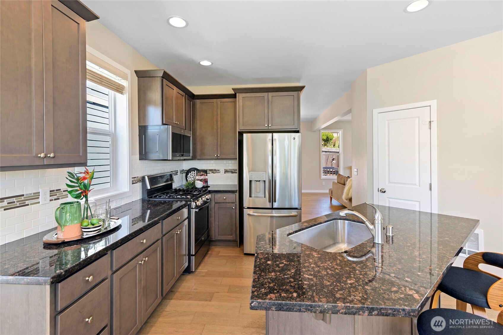 26442 GRAVITY Avenue Northeast Kingston, WA 98346 - Photo 9 of 40 a kitchen with kitchen island granite countertop a sink a stove and refrigerator