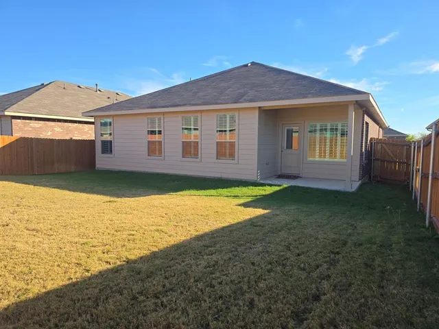 a view of a house with a yard and a large tree