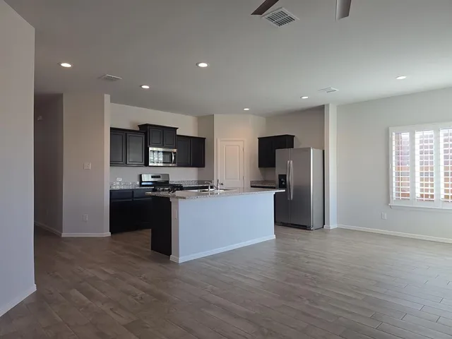 a large kitchen with stainless steel appliances granite countertop a refrigerator and a stove