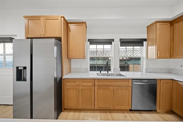 a kitchen with stainless steel appliances granite countertop a refrigerator and a sink