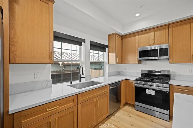 a kitchen with stainless steel appliances a stove sink microwave and cabinets