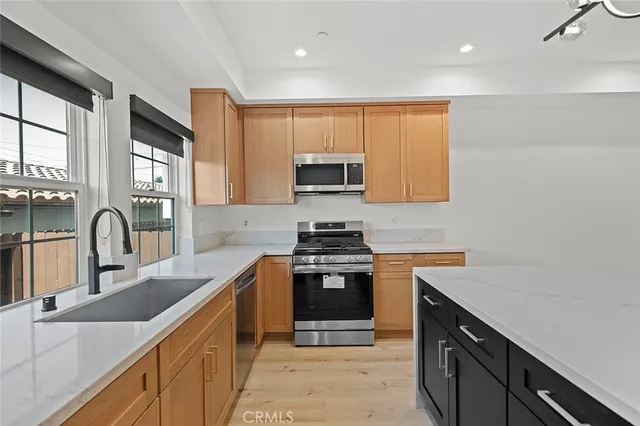 a kitchen with stainless steel appliances granite countertop a sink stove and cabinets