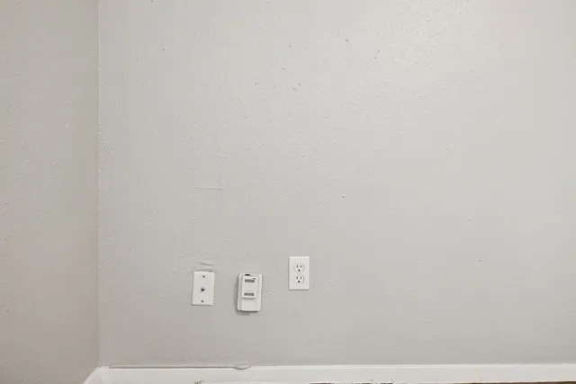 a view of an empty room with a chandelier fan