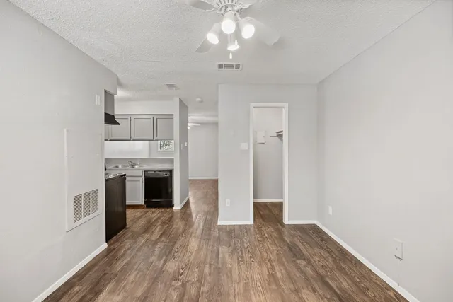 a view of a kitchen with a sink a refrigerator and wooden floor