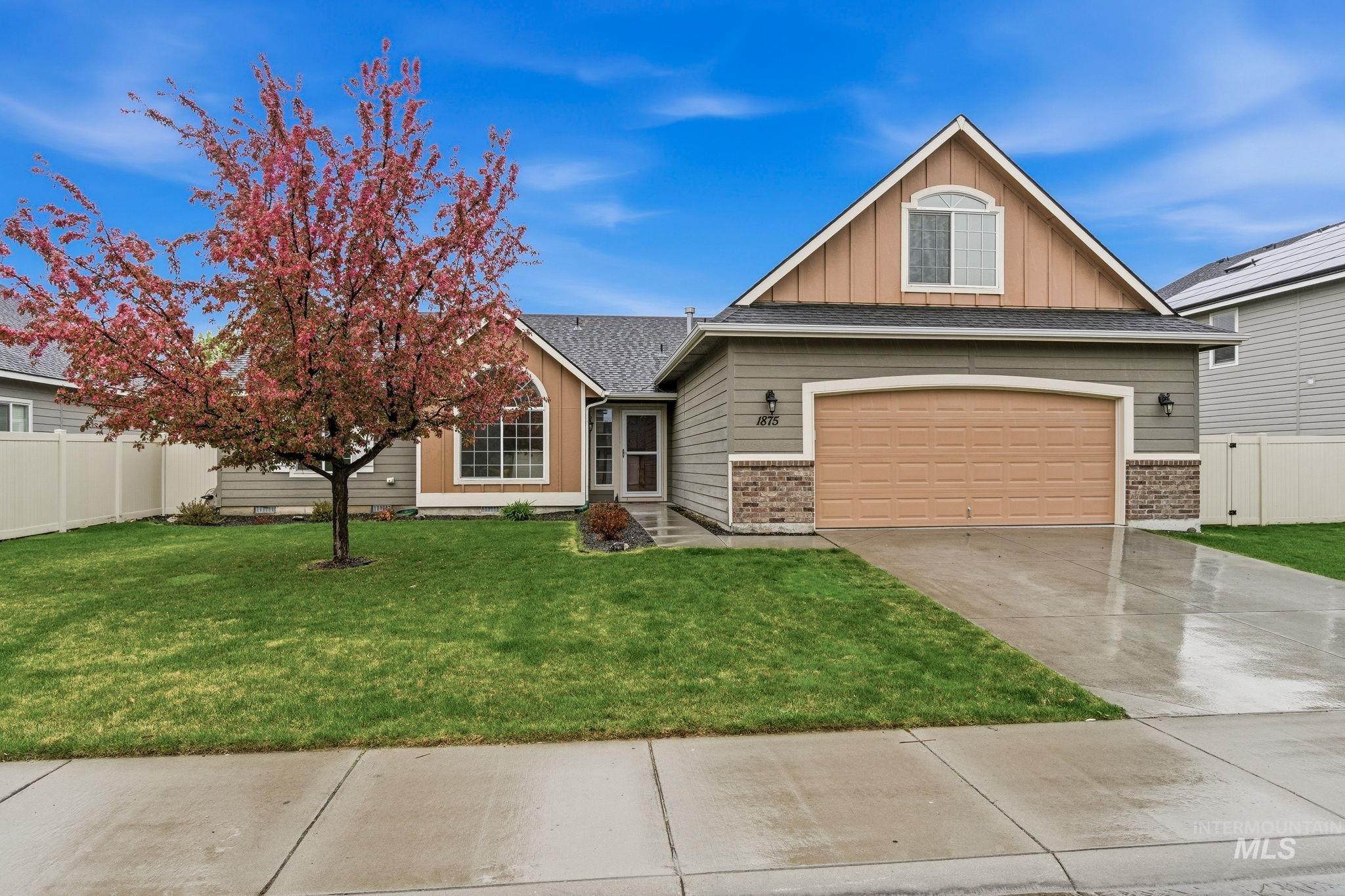 View of front of house featuring board and batten siding, brick siding, concrete driveway, and a garage