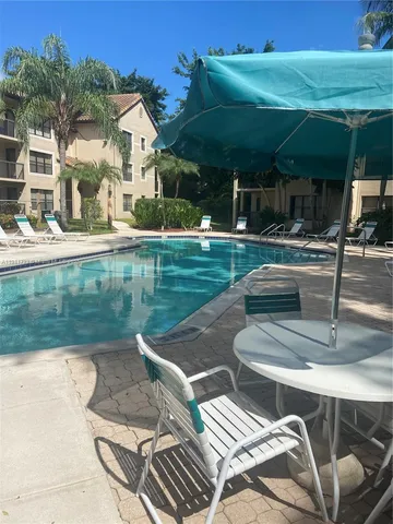 a view of a patio with dining table and chairs with a swimming pool