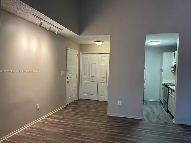 a view of empty room with wooden floor