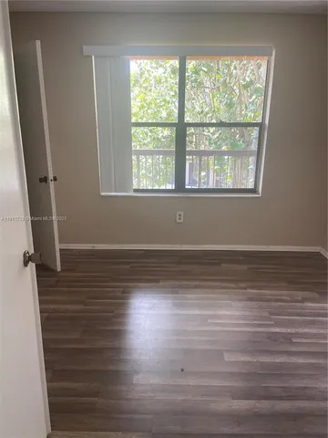 a room with wooden floor and windows