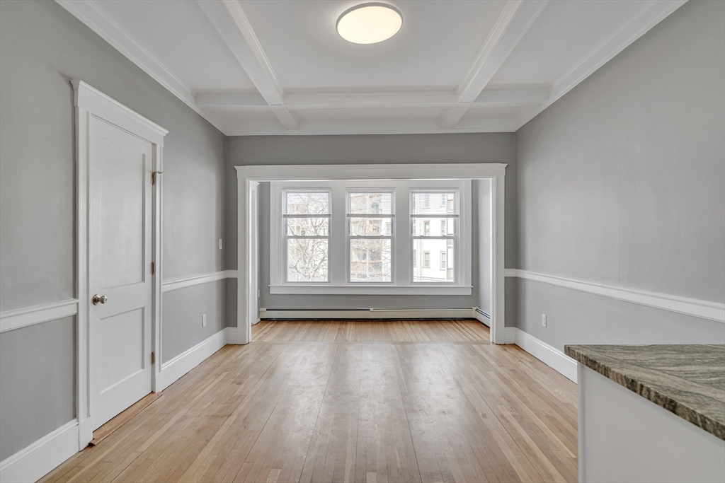 142 Sutherland Road, Unit 1 Boston, MA 02135 - Photo 3 of 16 wooden floor in an empty room with a window