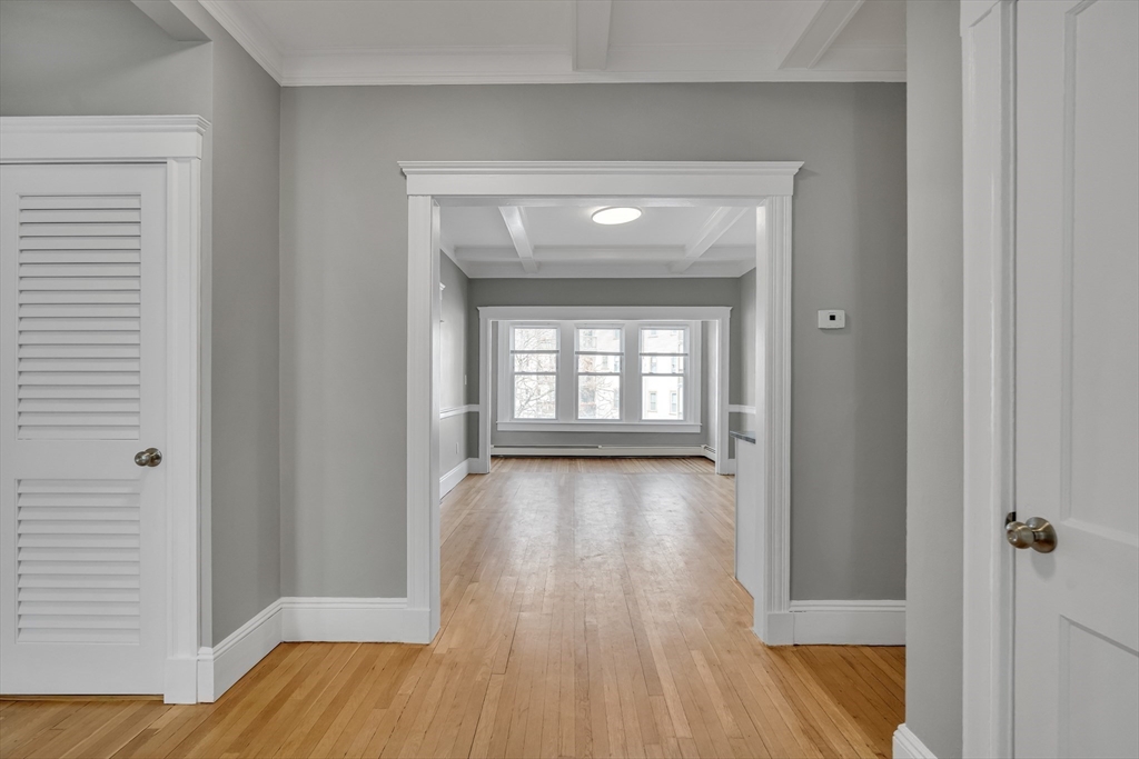 142 Sutherland Road, Unit 1 Boston, MA 02135 - Photo 8 of 16 a view of an empty room with wooden floor and a window