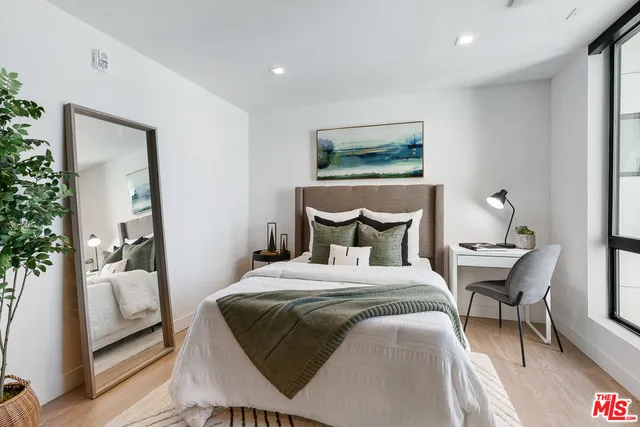 a bedroom with a bed and wooden floor