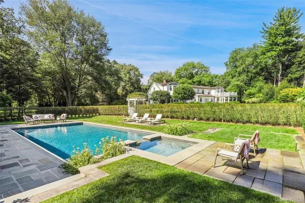 a view of a swimming pool and lounge chairs in back yard