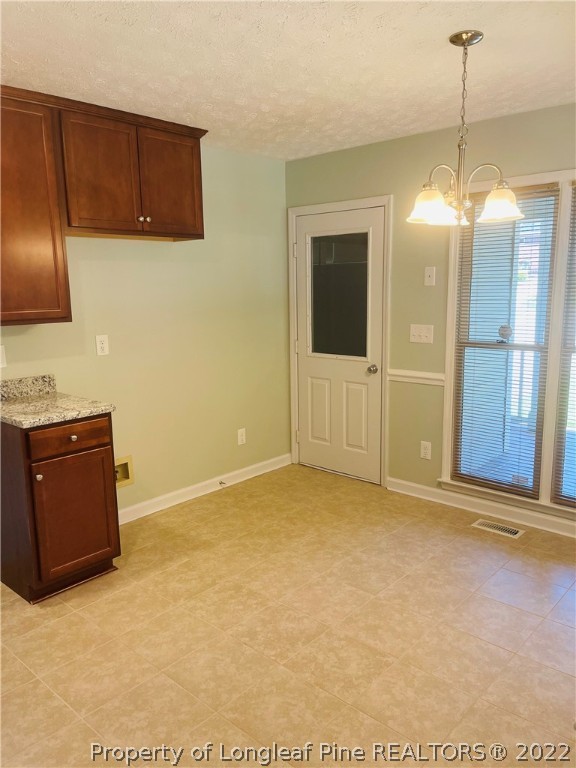 6501 Applewhite Road Fayetteville, NC 28304 - Photo 11 of 17 a view of an empty room with cabinet and chandelier