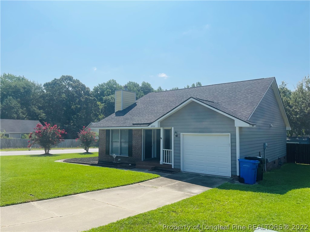 6501 Applewhite Road Fayetteville, NC 28304 - Photo 2 of 17 a front view of a house with a yard and garage