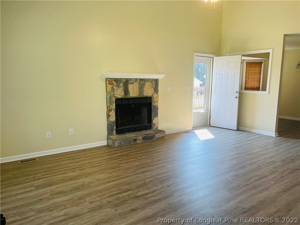 6501 Applewhite Road Fayetteville, NC 28304 - Photo 7 of 17 a view of an empty room with wooden floor fireplace and a window