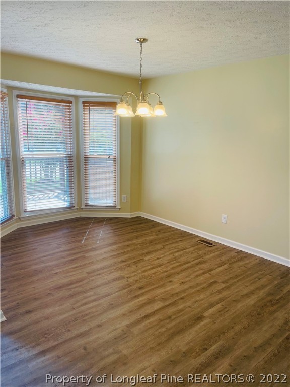 6501 Applewhite Road Fayetteville, NC 28304 - Photo 8 of 17 an empty room with wooden floor and windows