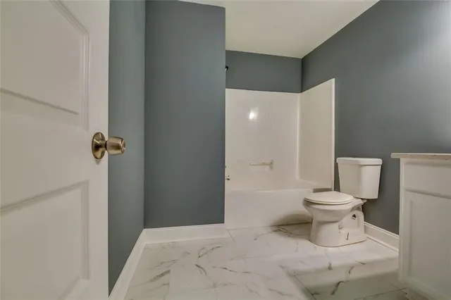 a bathroom with a toilet and a shower
