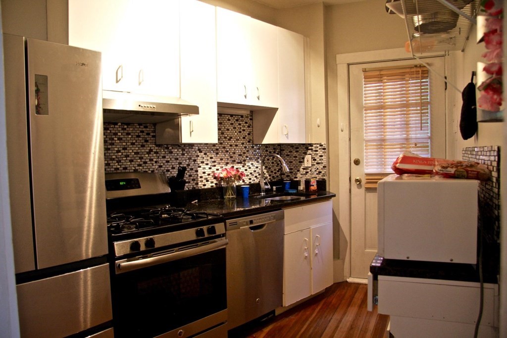 a kitchen with stainless steel appliances a refrigerator sink and stove