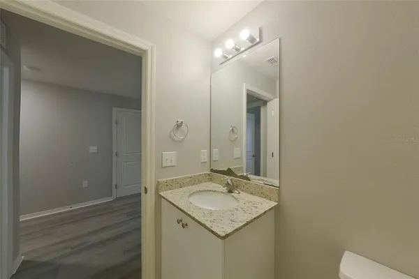 a bathroom with a granite countertop sink and a mirror