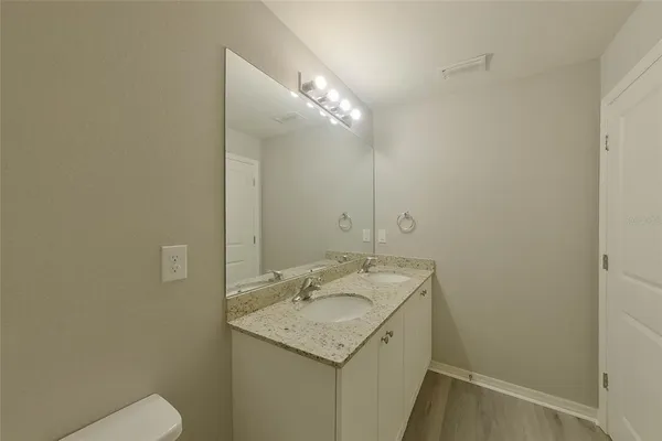 a bathroom with a granite countertop sink and a mirror