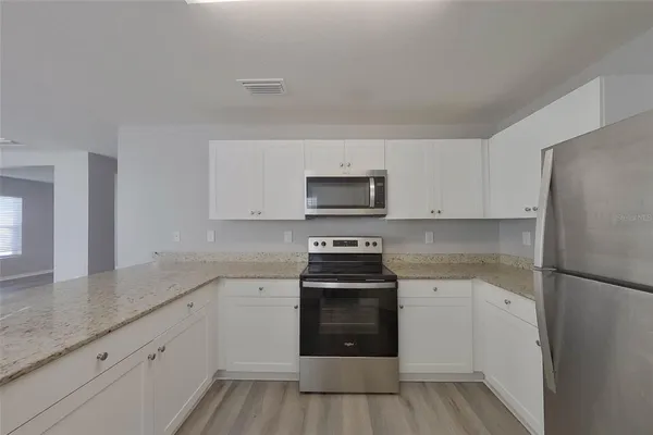 a kitchen with white cabinets and stainless steel appliances