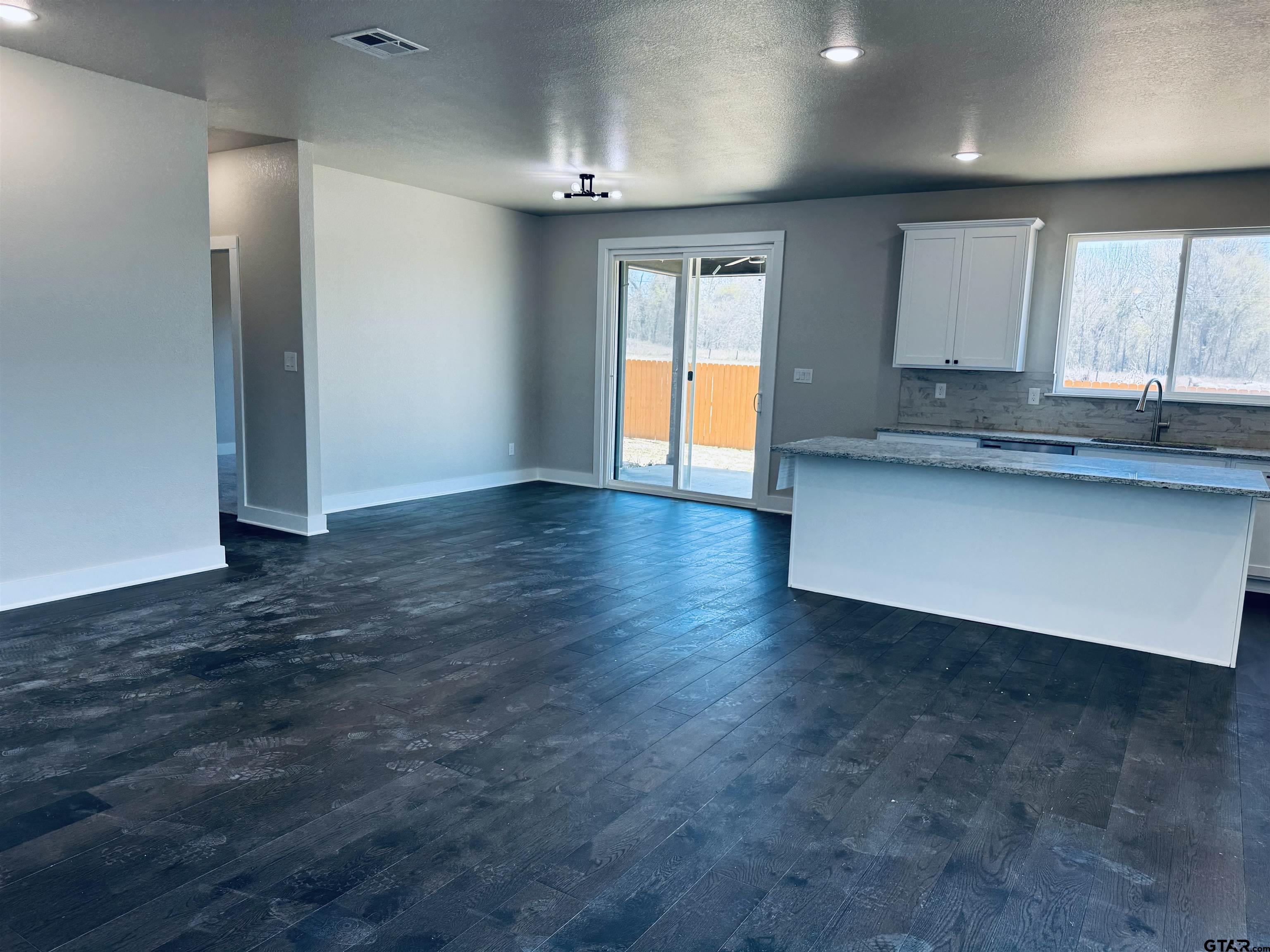 15525 Greenhouse Way Lindale, TX 75771 - Photo 3 of 7 an empty room with wooden floor and windows