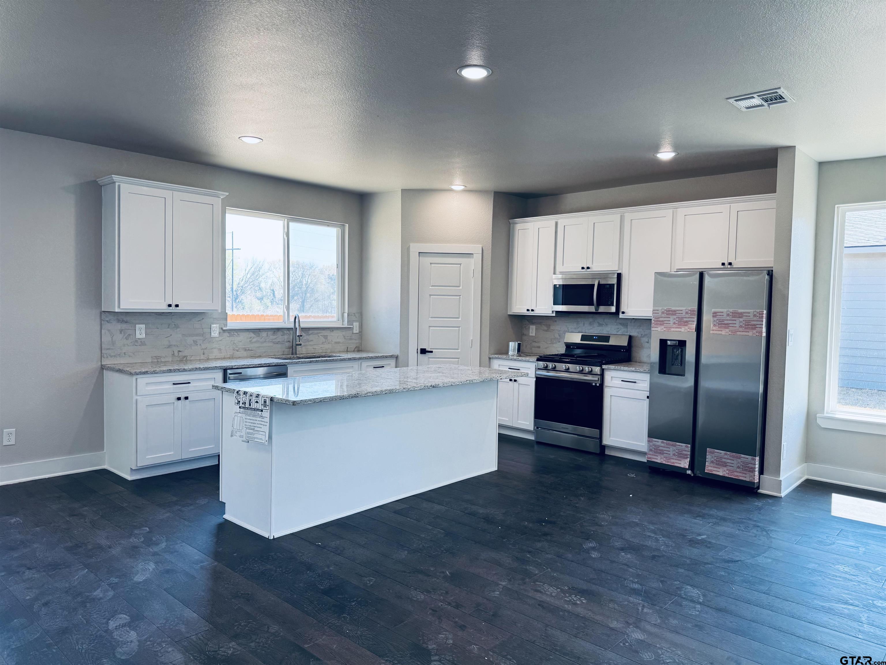 15525 Greenhouse Way Lindale, TX 75771 - Photo 4 of 7 a kitchen with granite countertop white cabinets and stainless steel appliances