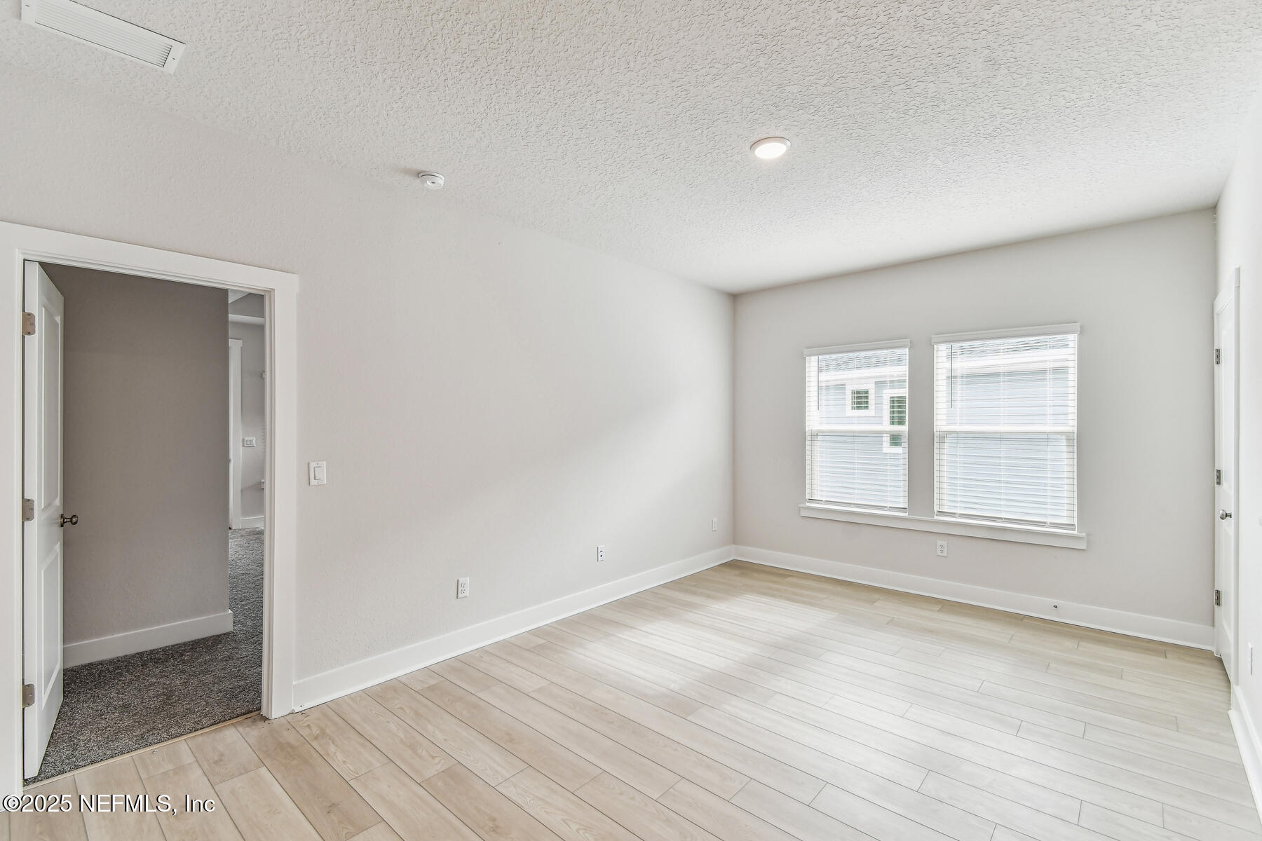 10085 Element Road Jacksonville, FL 32256 - Photo 13 of 24 an empty room with wooden floor and windows
