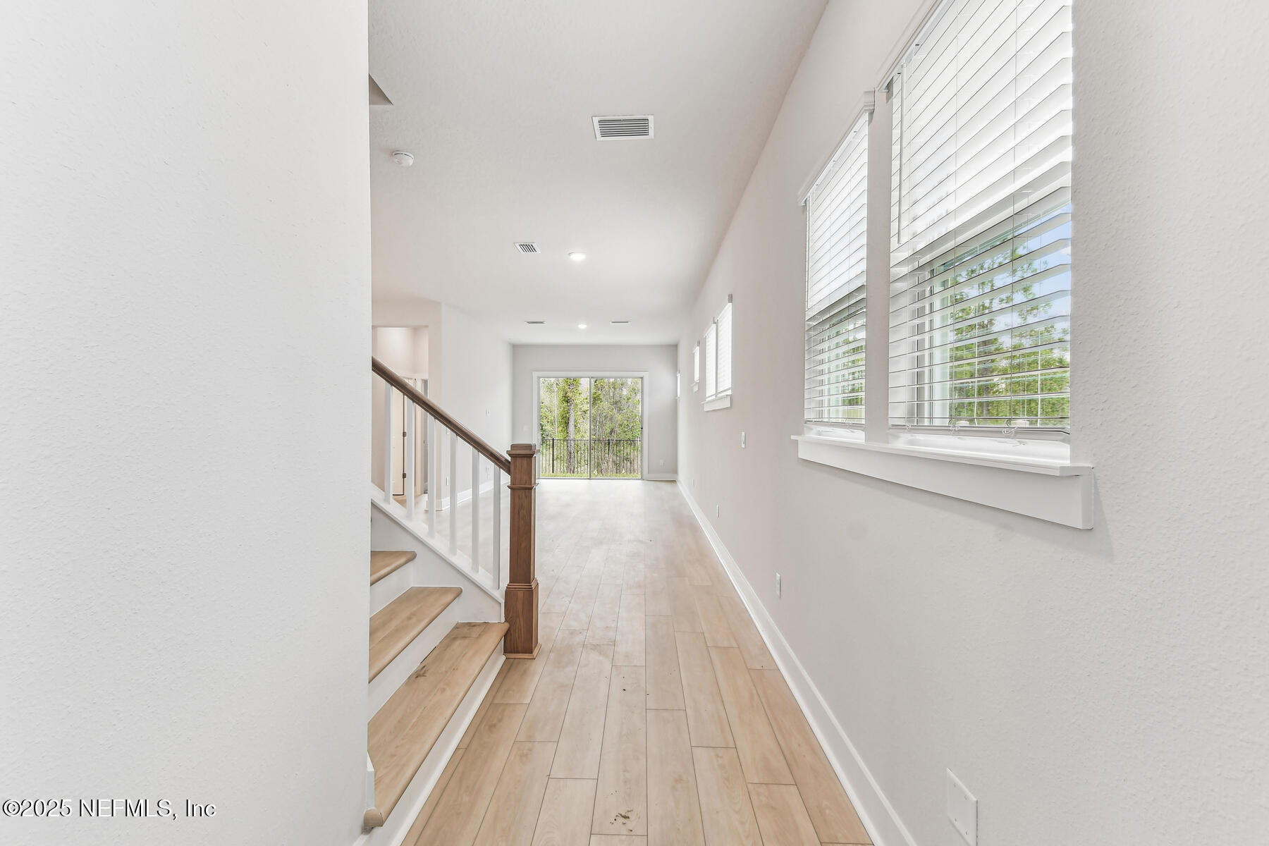 10085 Element Road Jacksonville, FL 32256 - Photo 9 of 24 a view of a hallway with wooden floor and staircase