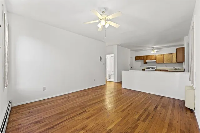 a view of a kitchen with wooden floor and a ceiling fan
