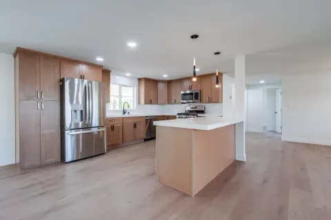 a kitchen with a refrigerator sink and cabinets