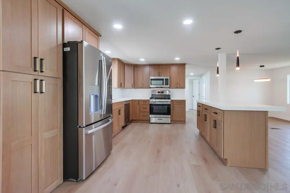 650 South Rancho Santa Fe Road, Unit 328 San Marcos, CA 92078 - Photo 12 of 22 a kitchen with stainless steel appliances granite countertop a refrigerator and a stove top oven