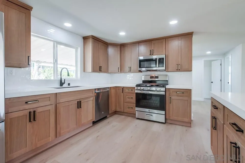 650 South Rancho Santa Fe Road, Unit 328 San Marcos, CA 92078 - Photo 13 of 22 a kitchen with granite countertop white cabinets and stainless steel appliances
