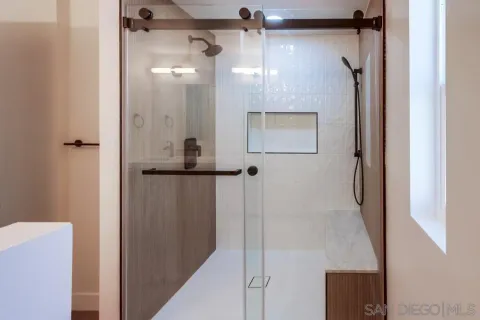 a bathroom with a glass shower door and a sink