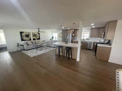 a living room with kitchen island furniture and a wooden floor