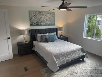 a bedroom with a bed and a painting on the wall