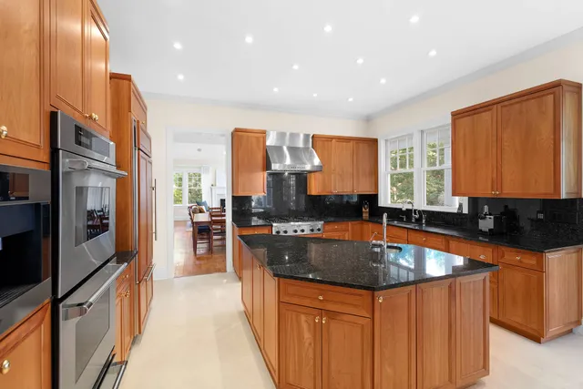 a kitchen with stainless steel appliances granite countertop a sink a stove and a refrigerator
